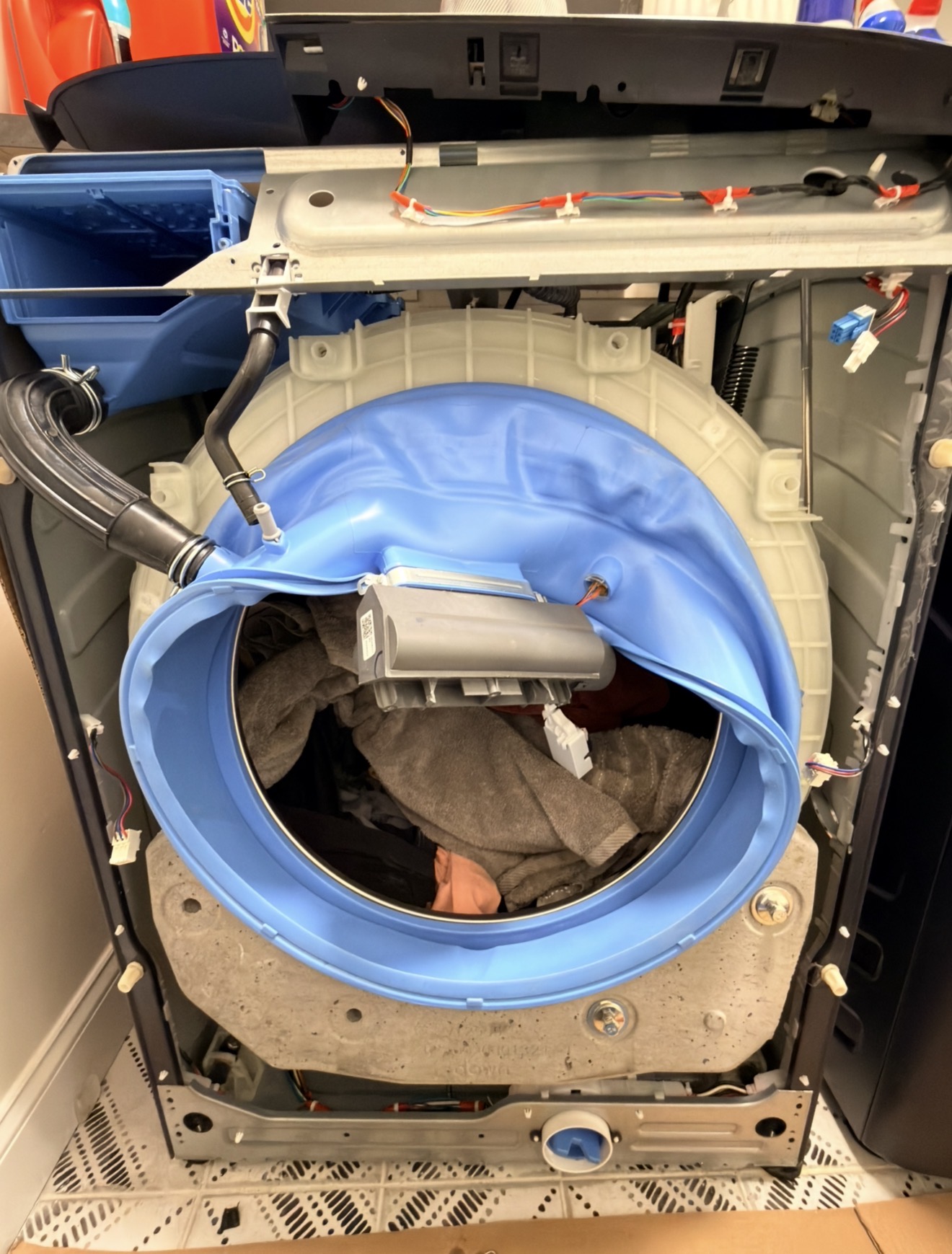 GE front-load washer opened with blue door gasket boot peeled back — drain pump and gasket repair on Staten Island